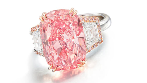 The 11.15-carat “Williamson Pink Star” is current set in a ring with trapeze-cut diamonds and brilliant-cut pink melee. The diamond sold for $57.7 million Friday at Sotheby’s Hong Kong. (Image courtesy of Sotheby’s)
