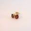 Gold earrings with red stones, angled view