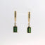 Earrings featuring emerald cut green stones with gold settings, front view