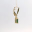 Close-up of gold earrings with green stone, side view