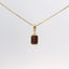 gold pendant with an emerald-cut red stone, front view